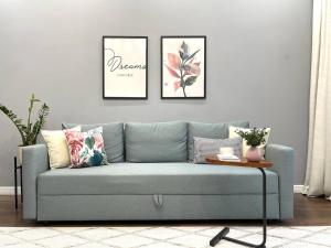 a blue couch in a living room with three pictures on the wall at GreenLine Terra in Astana +22 photos