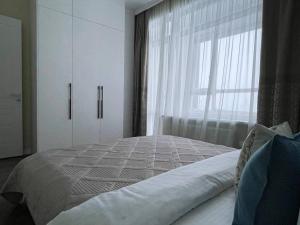 a bedroom with a large bed with a window at GreenLine Terra in Astana