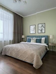 a bedroom with a large bed and a window at GreenLine Terra in Astana