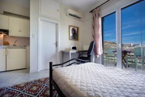 1 dormitorio con 1 cama y cocina con balcón en Penthhouse Studio next to the beach, en Suda