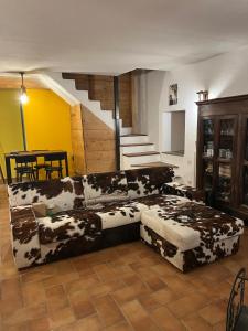 a living room with a cow print couch and stairs at Il Cottage in Castel di Sangro +54 photos