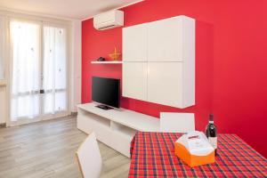 a red room with a tv and a red wall at Apartment Alba Gardena in Bardolino