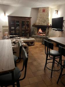 a living room with a fireplace and tables and chairs at Il Cottage in Castel di Sangro