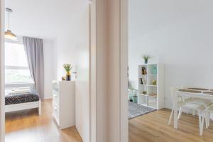 a white room with a desk and a table at Urban Chic - Luxury 2-Bedroom Apartment in Warsaw City Center, Pereca Street in Warsaw