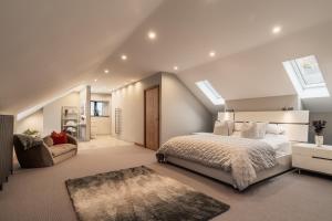 a bedroom with a large bed and a staircase at Midways, Stunning Retreat in the Heart of Bowness in Bowness-on-Windermere +57 photos