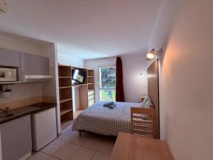 a small room with a bed and a kitchen at Le Clos d'Aix studio 105 parking in Aix-en-Provence