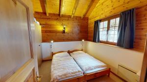 a small bedroom with a bed in a wooden room at Tschuggen TU78 in Blatten bei Naters +9 photos