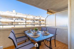 une table et des chaises sur un balcon avec vue sur un immeuble dans l'établissement Mediterranean Way - Paradis Park, à La Pineda
