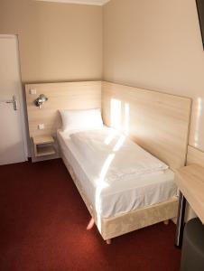 ein Schlafzimmer mit einem weißen Bett in einem Zimmer in der Unterkunft Rasthof & Motel Hermsdorfer Kreuz in Hermsdorf