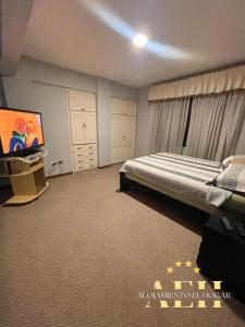 a bedroom with a bed and a flat screen tv at El Hogar - Sucursal Calle Julio Mendez y Obispo Anaya con Garaje cubierta in Cochabamba