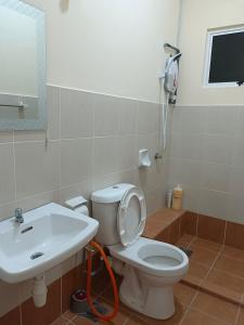 a bathroom with a white toilet and a sink at Seaview Emerald Sandakan in Sandakan