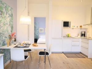 ヴェスターラントにあるBötticher Str. 9, W3, Weesterlönの白いキャビネットとテーブルと椅子のあるキッチン