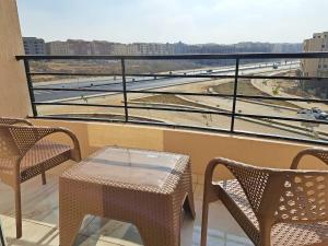 a balcony with a table and chairs and a view of a city at New Cairo Cozy Studio استديو فندقى بالتجمع in New cairo