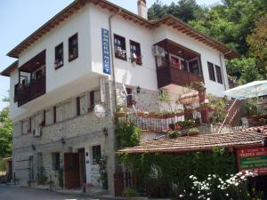 a white building with windows and balconies with flowers at Guest House Rimski Most in Melnik