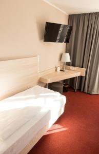 a hotel room with a bed and a desk at Rasthof & Motel Hermsdorfer Kreuz in Hermsdorf