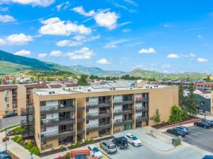 an apartment building with a parking lot and mountains in the background at Main St Wanderlust, Resort Bliss and Nearby Dining Delights in Park City