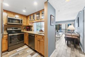 a kitchen with wooden cabinets and a table and a desk at Main St Wanderlust, Resort Bliss and Nearby Dining Delights in Park City