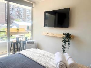 a bedroom with a flat screen tv on a wall at exclusive apartment with AC and parking in Santiago