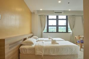 a hotel room with two beds and a window at Treewoods Residences in Cebu City +36 photos