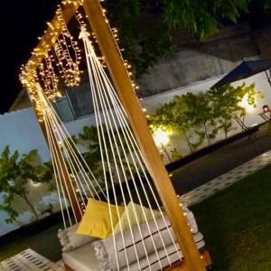 a swing with lights on it in a yard at Tiamo Rooms in Matara