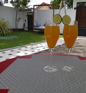 two glasses of orange juice sitting on a table at Tiamo Rooms in Matara