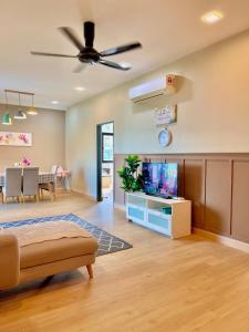a living room with a ceiling fan and a tv at JB Citywoods 2B2BR - 5min CIQ & HSAJB & Anga Clinic in Johor Bahru +10 photos