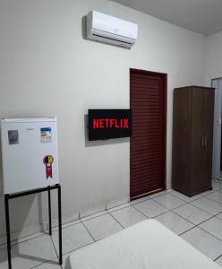 ein WC mit einem roten Ausstiegschild und einem Kühlschrank in der Unterkunft Hotel Leblon - SmarTV e Ar-Condicionado por Menos de 130,00 in Uberaba