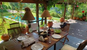 a wooden table with plates and lamps on a patio at Casa Dos Canais, River Cottage in Marco de Canavezes