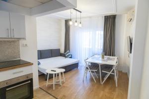 een klein appartement met een bed, een tafel en een keuken bij Lev Or Aparthotel in Boekarest