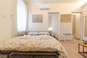 a bedroom with a bed with two towels on it at Teatro Romano Suites - Isabella in Trieste +10 photos