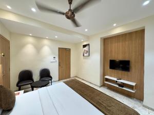 a bedroom with a large bed and two chairs at HOTEL TOUCHWOOD in Visakhapatnam
