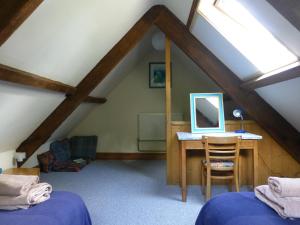 a attic room with a desk with a computer on it at Ty Cefn Tregib in Llandeilo +33 photos
