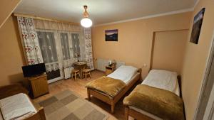 Habitación pequeña con 2 camas y TV. en Willa Pod Kopiencem, en Zakopane