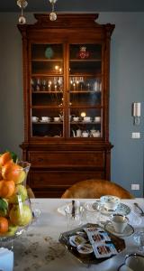 a table with a china cabinet with dishes on it at B&B Dàmur in Piazza Armerina