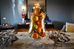 a glass vase filled with fruits and vegetables on a table at B&B Dàmur in Piazza Armerina
