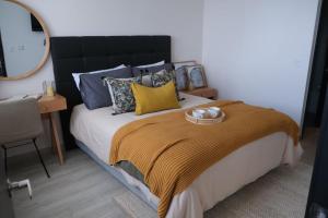 a bedroom with a large bed with a black headboard at Departamentos Wonderlust Dorotea in Puerto Natales