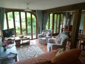 a living room with a couch and chairs and a tv at Ty Cefn Tregib in Llandeilo