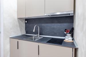 a kitchen with a sink and a counter top at Teatro Romano Suites - Francesca in Trieste +8 photos