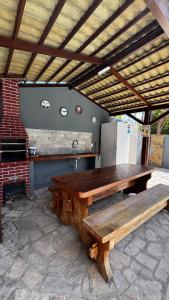 einen großen Holztisch und eine Bank in der Küche in der Unterkunft Casa Praia de Tabatinga 2 a 70m do Mar in Conde
