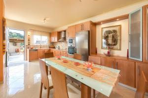 a kitchen with wooden cabinets and a large counter top at Natura House in Ialysos
