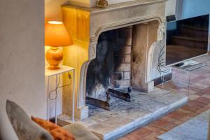 a living room with a stone fireplace with a lamp at #HP La maison des Lilas Large family house sleeps 12 garden in Seyssins