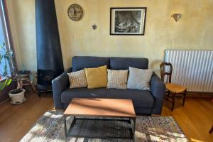 ein Wohnzimmer mit einem blauen Sofa und einem Tisch in der Unterkunft Appartement cosy au cœur de La Féclaz in La Feclaz