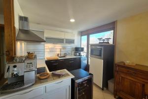 eine Küche mit Herd und Kühlschrank in der Unterkunft Appartement cosy au cœur de La Féclaz in La Feclaz + 9 Fotos