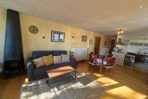 ein Wohnzimmer mit einer blauen Couch und einer Küche in der Unterkunft Appartement cosy au cœur de La Féclaz in La Feclaz