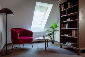 a living room with a pink chair and a table at Gostišče Pod Kostanji in Dobrna