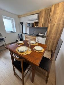 a kitchen with a wooden table with plates and glasses at Chalupa DEMÄNOVÁ in Liptovský Mikuláš +12 photos