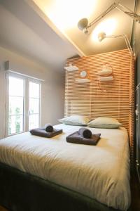 ein Schlafzimmer mit einem großen Bett mit zwei Handtüchern darauf in der Unterkunft La Villa Seventies - Parking gratuit in Angoulême