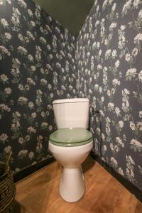 ein weißes WC im Bad mit Blumentapete in der Unterkunft La Villa Seventies - Parking gratuit in Angoulême + 20 Fotos