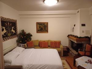a bedroom with a bed and a couch and a fireplace at Ξύλο & Παράδοση in Pavliani