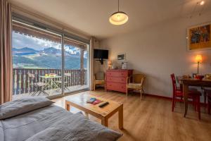 巴斯洛内特Escapade Perchée - Vue - Balcon - Parking的客厅设有大窗户、桌子和书桌